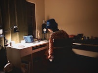 a person sitting at a desk with a laptop in front of him