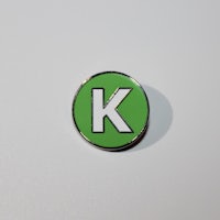 a green pin with the letter k on it